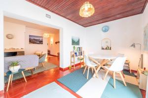 a dining room and living room with a table and chairs at Casa da Rita in Cascais
