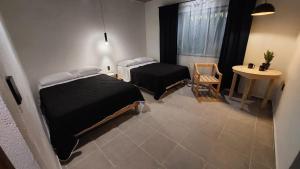 a room with two beds and a table and a window at Hotel Caminos in Chignahuapan +36 photos