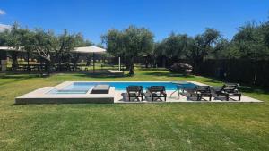 a yard with a pool with chairs and a table at OlivaNegra Resort - Oliva2 in Maipú