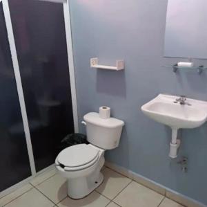 a bathroom with a toilet and a sink at Cómodos cuartos para tu economia in Mazatlán