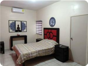 a bedroom with a bed and a clock on the wall at Cómodos cuartos para tu economia in Mazatlán