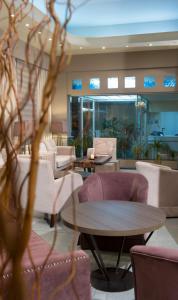 hol z kanapami, stołami i krzesłami w obiekcie Aliakmon Hotel w mieście Kozani