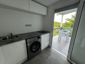 a kitchen with a sink and a washing machine at L'O - Au cœur de la Grande-Terre - T2 in Morne-à-lʼEau +3 photos