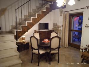 una sala da pranzo con tavolo, sedie e scala di Il Frantoio di Franco a Rocchetta a Volturno