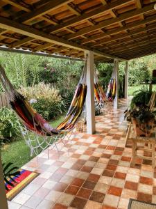 una fila de hamacas colgando de una pérgola en Vila Santíssimo Hospedagem e Café, en PatrimÃ´nio da Penha