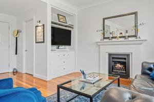 a living room with a fireplace and a tv at Villa Above Par, Privately Managed within Cypress Lakes Resort, Premier 2 Storey Villa, 2 Bedrooms, both with Private Ensuites, Light Breakfast included in Pokolbin