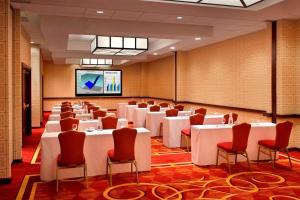 a conference room with tables and chairs and a screen at Trumbull Marriott Shelton in Trumbull
