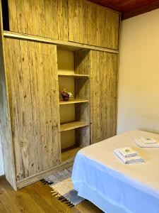 a room with a bed and a wooden cabinet at Chalé nas Árvores in São Francisco Xavier +43 photos