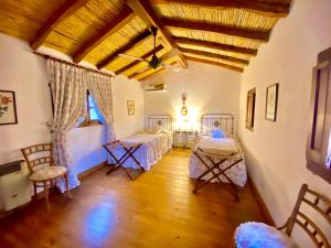 a bedroom with two beds and a wooden floor at El Palomar casa de campo in Churqui Cañada