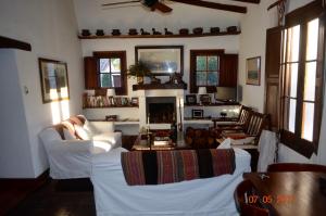 a living room with white couches and a fireplace at El Palomar casa de campo in Churqui Cañada