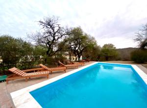 a swimming pool with chaise lounge chairs and a swimming pool at El Palomar casa de campo in Churqui Cañada