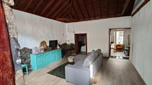 Una sala de estar con un sofá y un televisor. en Casa Cecilia, en Los Silos