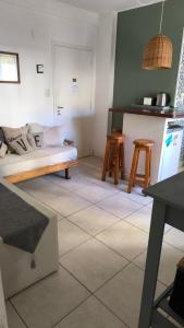 een woonkamer met een bed en 2 krukken bij Depto Gascón in Mar del Plata