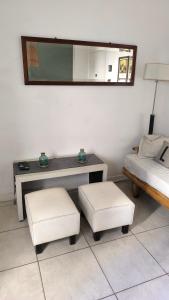 een kamer met een tafel, 2 krukken en een spiegel bij Depto Gascón in Mar del Plata