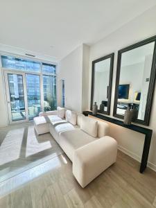 a living room with a white couch and large windows at Toronto Downtown Core Condo 2 BED 2 BATH in Toronto