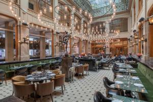 a restaurant with tables and chairs and chandeliers at W Amsterdam in Amsterdam