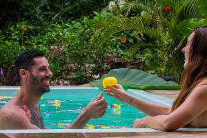 马尔多纳多港Casa Amazonas的游泳池里一男一女拿着一根香蕉