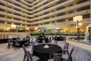 a dining room with tables and chairs in a building at Sheraton West Des Moines in West Des Moines