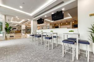 a lobby with a bar with stools and televisions at Modern Ft Lauderdale Condo about 7 Mi to Airport! in Fort Lauderdale