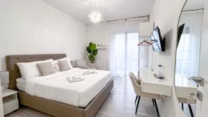 a white bedroom with a large bed and a desk at Dream & Relax in San Donato Milanese