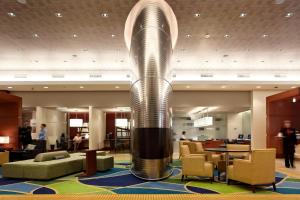 a lobby with a spiral column in the middle of a building at Marriott Montreal Airport In-Terminal Hotel in Dorval +37 photos
