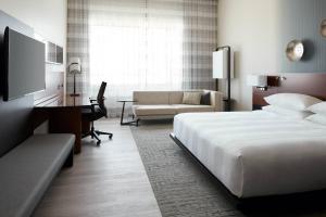 a hotel room with a bed and a desk at Marriott Montreal Airport In-Terminal Hotel in Dorval