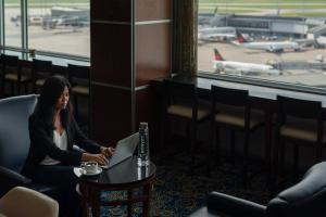 a woman sitting in a waiting room at an airport at Marriott Montreal Airport In-Terminal Hotel in Dorval