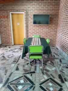 a table with chairs and a television on a brick wall at Alquiler en Playa Unión in Playa Unión