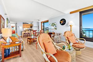 un salon avec un canapé, des fauteuils et une table dans l'établissement Maui Kai 1001, à Kahana