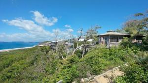 a house on top of a hill next to the ocean at 'The Yurt' by HolidayCo in Hardys Bay