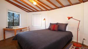 a bedroom with a bed and a desk and a window at 'The Yurt' by HolidayCo in Hardys Bay