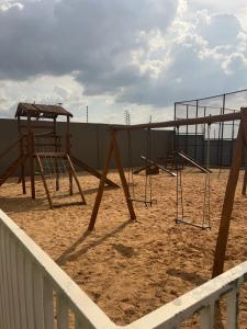 a playground with two swings in the sand at Lindo apartamento mobiliado, ar condicionado, cozinha equipada in Imperatriz
