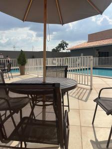 a wooden table with an umbrella on a patio at Impera House Ar nos dois quartos in Imperatriz