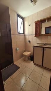 Un baño con inodoro, lavabo y ventana. en AP Varanda do Mar - Rio das Ostras, en Rio das Ostras