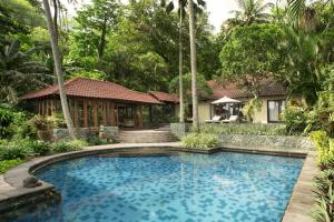a swimming pool in front of a house at Sheraton Senggigi Beach Resort in Senggigi