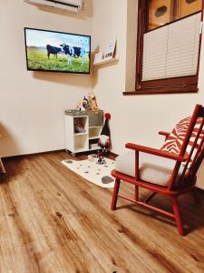 a living room with a chair and a tv on the wall at See You House, Terme Čatež 153 in Čatež ob Savi