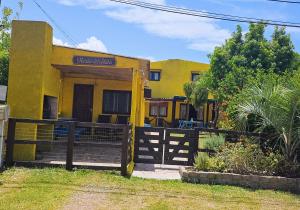 a yellow house with a fence in front of it at Mirador del Diablo in Punta Del Diablo