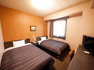Ένα ή περισσότερα κρεβάτια σε δωμάτιο στο Hotel Route-Inn Court Minami Matsumoto