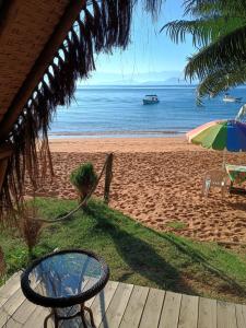 a table and an umbrella on the beach at Chalés do Pedro Hospedagem e Restaurante in Praia de Araçatiba