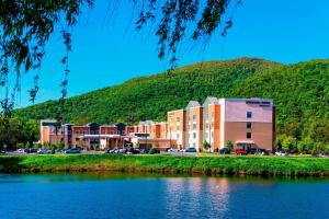 um edifício ao lado de uma massa de água com uma montanha em SpringHill Suites by Marriott Fishkill em Fishkill