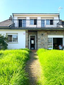 ein Haus mit einem Balkon darauf in der Unterkunft Casa das Cunchas a 50 metros de Area da Cruz in San Vicente do Mar