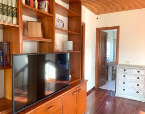 ein Wohnzimmer mit einem Fernseher auf einem hölzernen Entertainment-Center in der Unterkunft Casa das Cunchas a 50 metros de Area da Cruz in San Vicente do Mar