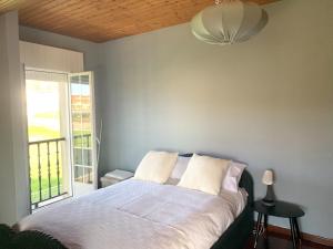 ein Schlafzimmer mit einem Bett und einem großen Fenster in der Unterkunft Casa das Cunchas a 50 metros de Area da Cruz in San Vicente do Mar