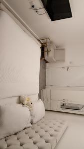 a white room with a bed with white pillows at Romford Luxe Home in Goodmayes