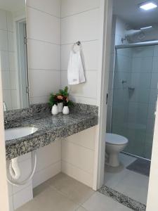 un bagno con lavandino, WC e doccia di Apartamento Beira-mar orla sul a Ilhéus