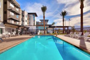 a swimming pool with palm trees and a building at Residence Inn by Marriott La Quinta in La Quinta