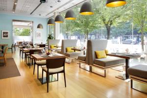 a restaurant with tables and chairs and large windows at Hotel Zinema7 in Donostia-San Sebastián