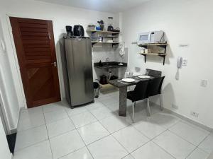 a kitchen with a refrigerator and a table and chairs at Charme 2 in Natal +3 photos