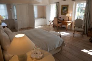 a bedroom with a bed and a table with a lamp at Château du Tertre in Arsac