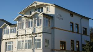 a white building with a balcony on the side of it at Villa Margarete in Sassnitz